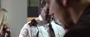 Movie still from “Trust” (2010), directed by David Schwimmer – A man in a police uniform with a walkie talkie in his ear; Close Up shot, Over the shoulder angle