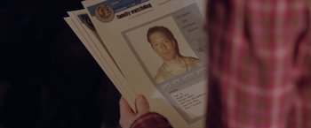 Movie still from “Trust” (2010), directed by David Schwimmer – A person looking at an image of a man; Extreme Close Up shot, High angle