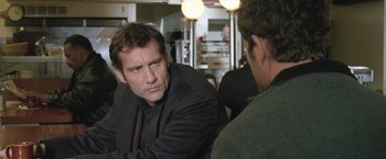 Movie still from “Trust” (2010), directed by David Schwimmer – A man in a black jacket is talking to another man in a black jacket; Close Up shot, Over the shoulder angle