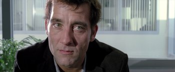 Movie still from “Trust” (2010), directed by David Schwimmer – A man's face in a black suit; Close Up shot, Low angle