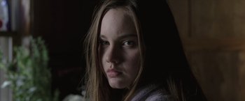 Movie still from “Trust” (2010), directed by David Schwimmer – A young woman with long hair is looking at the camera; Close Up shot, Low angle