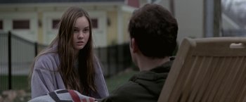 Movie still from “Trust” (2010), directed by David Schwimmer – A young girl and a young man sitting on a lawn chair; Medium shot, Over the shoulder angle