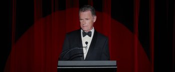 Movie still from “Truth” (2015), directed by James Vanderbilt – A man in a tuxedo is standing at a podium; Close Up shot, High angle