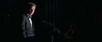 Movie still from “Truth” (2015), directed by James Vanderbilt – A man standing at a podium in front of microphones; Medium shot, Low angle