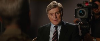 Movie still from “Truth” (2015), directed by James Vanderbilt – An older man wearing a suit and tie; Close Up shot, Over the shoulder angle