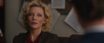 Movie still from “Truth” (2015), directed by James Vanderbilt – A woman sitting in front of a wall with a book on the wall; Close Up shot, Over the shoulder angle