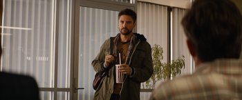 Movie still from “Truth” (2015), directed by James Vanderbilt – A man standing in front of a window holding a drink; Medium shot, Over the shoulder angle