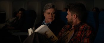 Movie still from “Truth” (2015), directed by James Vanderbilt – A man sitting next to another man on a plane; Medium shot, Over the shoulder angle
