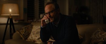 Movie still from “Truth” (2015), directed by James Vanderbilt – A man sitting on a couch talking on a phone; Close Up shot, Over the shoulder angle