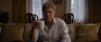 Movie still from “Truth” (2015), directed by James Vanderbilt – An older man holding a coffee cup while sitting on a couch; Close Up shot, Low angle