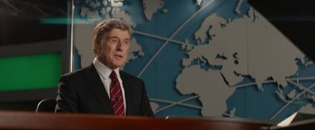 Movie still from “Truth” (2015), directed by James Vanderbilt – A man wearing a suit and tie in front of a map; Medium shot, Over the shoulder angle