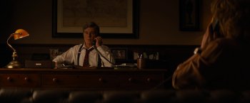 Movie still from “Truth” (2015), directed by James Vanderbilt – A man sitting at a desk talking on the phone; Medium shot, Over the shoulder angle