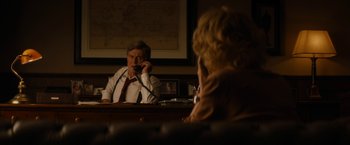 Movie still from “Truth” (2015), directed by James Vanderbilt – A man sitting at a desk in front of a woman; Medium shot, Over the shoulder angle