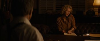 Movie still from “Truth” (2015), directed by James Vanderbilt – A woman sitting at a table in a room; Medium shot, Over the shoulder angle