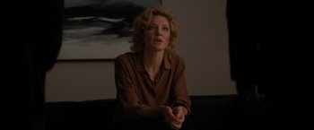 Movie still from “Truth” (2015), directed by James Vanderbilt – A woman in a brown shirt sitting in front of a painting; Medium shot, Low angle