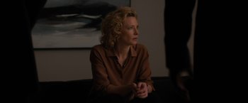 Movie still from “Truth” (2015), directed by James Vanderbilt – A woman sitting on a couch in front of a painting; Medium shot, Over the shoulder angle