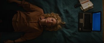 Movie still from “Truth” (2015), directed by James Vanderbilt – A woman laying on a bed with her eyes closed; Medium shot, Overhead angle