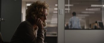 Movie still from “Truth” (2015), directed by James Vanderbilt – A woman talking on a phone in an office setting; Medium shot, High angle
