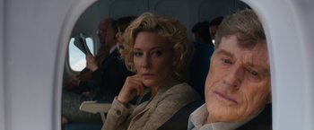 Movie still from “Truth” (2015), directed by James Vanderbilt – A woman sitting on a plane with her hand under her chin; Close Up shot, Over the shoulder angle