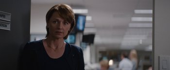 Movie still from “Truth” (2015), directed by James Vanderbilt – A woman standing in a room with a bunch of people in the background; Close Up shot, Over the shoulder angle