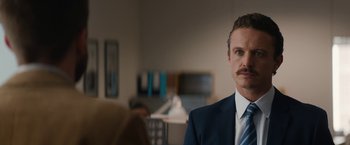Movie still from “Truth” (2015), directed by James Vanderbilt – A person wearing a suit and tie; Close Up shot, Over the shoulder angle