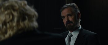 Movie still from “Truth” (2015), directed by James Vanderbilt – A man in a suit and tie looking at the camera; Close Up shot, Over the shoulder angle