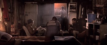 Movie still from “Tsotsi” (2005), directed by Gavin Hood – A group of people sitting on a couch in front of a window; Wide shot, Low angle