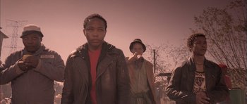 Movie still from “Tsotsi” (2005), directed by Gavin Hood – A group of young men standing next to each other; Medium shot, Low angle