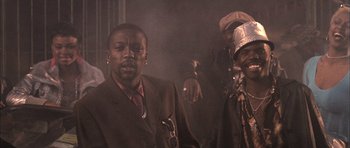Movie still from “Tsotsi” (2005), directed by Gavin Hood – A group of men standing next to each other in a room; Medium shot, Low angle
