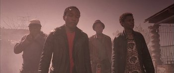 Movie still from “Tsotsi” (2005), directed by Gavin Hood – A group of men standing next to each other; Medium shot, Low angle