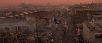 Movie still from “Tsotsi” (2005), directed by Gavin Hood – A group of people walking down a dirt road; Extreme Wide shot, High angle