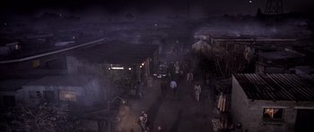 Movie still from “Tsotsi” (2005), directed by Gavin Hood – A group of people walking down a street at night; Extreme Wide shot, High angle