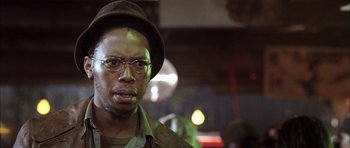 Movie still from “Tsotsi” (2005), directed by Gavin Hood – A person wearing glasses and a hat; Close Up shot, Low angle