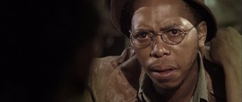 Movie still from “Tsotsi” (2005), directed by Gavin Hood – A person wearing glasses and a hat; Close Up shot, Low angle