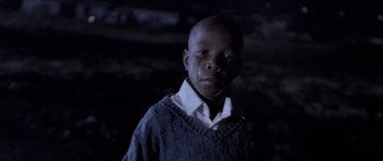Movie still from “Tsotsi” (2005), directed by Gavin Hood – A young boy wearing a sweater standing in the dark; Close Up shot, Low angle