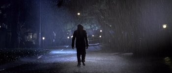 Movie still from “Tsotsi” (2005), directed by Gavin Hood – A man walking down a street in the rain at night; Wide shot, Low angle