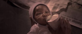 Movie still from “Tsotsi” (2005), directed by Gavin Hood – A baby drinking milk from a cup; Extreme Close Up shot, High angle