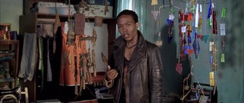 Movie still from “Tsotsi” (2005), directed by Gavin Hood – A man in a leather jacket is posing for a picture; Close Up shot, Low angle