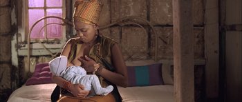 Movie still from “Tsotsi” (2005), directed by Gavin Hood – A woman holding a baby in her arms; Medium shot, Over the shoulder angle