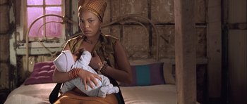 Movie still from “Tsotsi” (2005), directed by Gavin Hood – A woman sitting on a bed holding a baby; Close Up shot, Over the shoulder angle