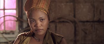 Movie still from “Tsotsi” (2005), directed by Gavin Hood – A woman wearing a headdress is posing for a picture; Close Up shot, Low angle