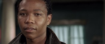 Movie still from “Tsotsi” (2005), directed by Gavin Hood – A person wearing a leather jacket; Close Up shot, Low angle