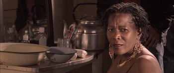 Movie still from “Tsotsi” (2005), directed by Gavin Hood – An older woman sitting in front of a tea pot; Close Up shot, Low angle
