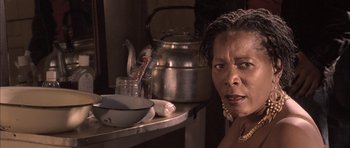 Movie still from “Tsotsi” (2005), directed by Gavin Hood – A woman sitting in front of a tea pot; Close Up shot, Low angle