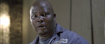 Movie still from “Tsotsi” (2005), directed by Gavin Hood – A person wearing a prison uniform; Close Up shot, Low angle