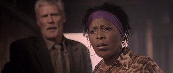 Movie still from “Tsotsi” (2005), directed by Gavin Hood – An older man and a younger woman are looking at the camera; Close Up shot, Low angle