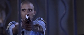 Movie still from “Tsotsi” (2005), directed by Gavin Hood – A man holding a gun in his hand; Close Up shot, Low angle