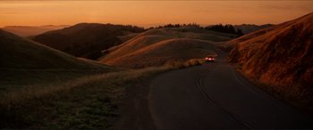 Movie still from “Tucker: The Man and His Dream” (1988), directed by Francis Ford Coppola – A car driving down a road in the middle of the night; Extreme Wide shot, High angle