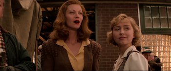 Movie still from “Tucker: The Man and His Dream” (1988), directed by Francis Ford Coppola – Two women standing next to each other in front of a brick building; Medium shot, Low angle