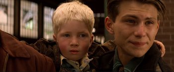 Movie still from “Tucker: The Man and His Dream” (1988), directed by Francis Ford Coppola – A child with a man in the background; Close Up shot, Low angle